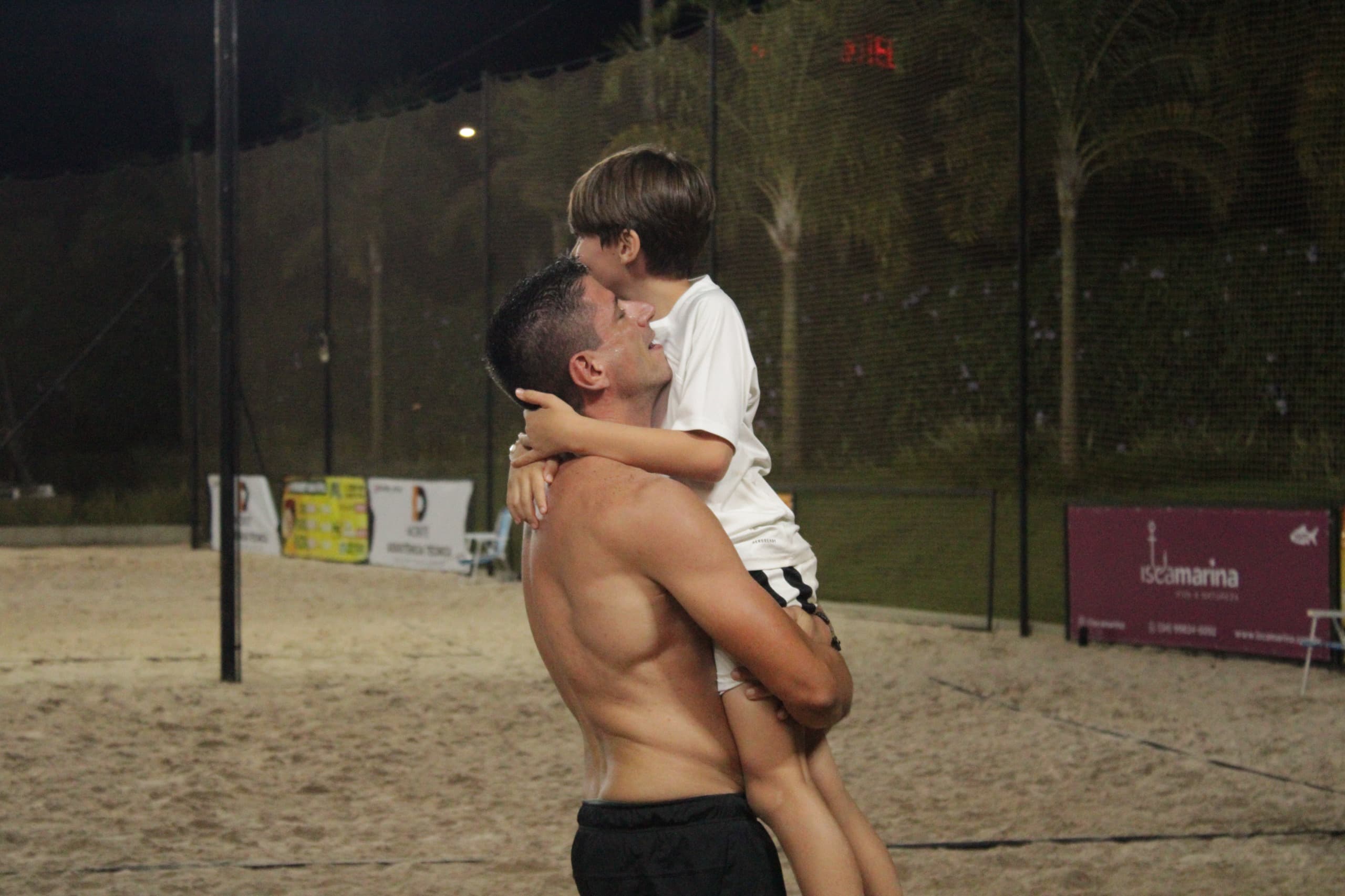 Atleta comemorando com o filho no colo